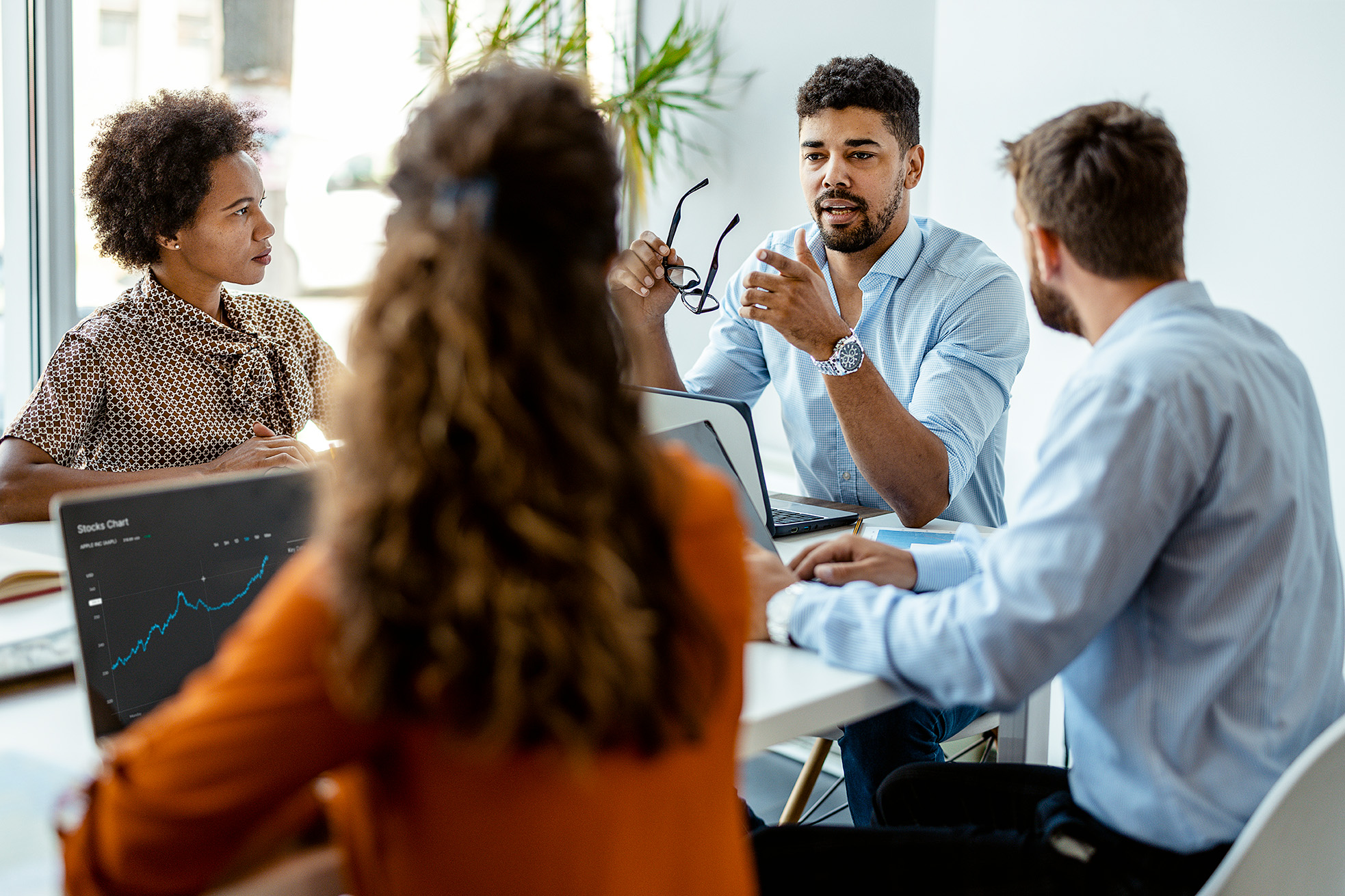 Sie sehen zwei Männer und zwei Frauen gemeinsam in einer Besprechung an einem Tisch sitzen. Vor ihnen stehen Laptops mit dem E-Learning Kurs zum Thema Soft Skills.