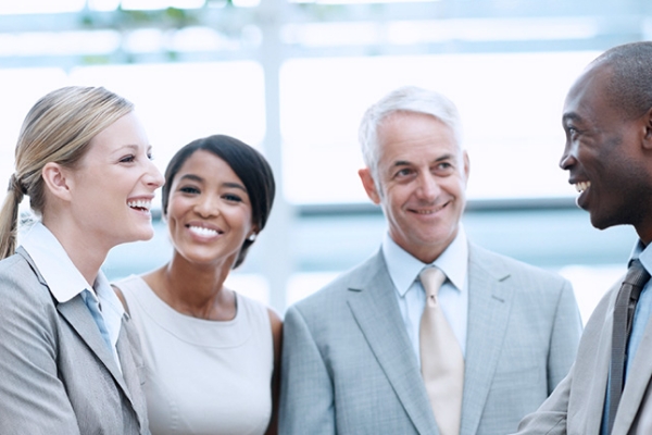 Sie sehen den Screen unseres Kurses Code of Conduct. Zu sehen sind zwei Frauen und zwei Männer in Business-Kleidung, die sich miteinander unterhalten.