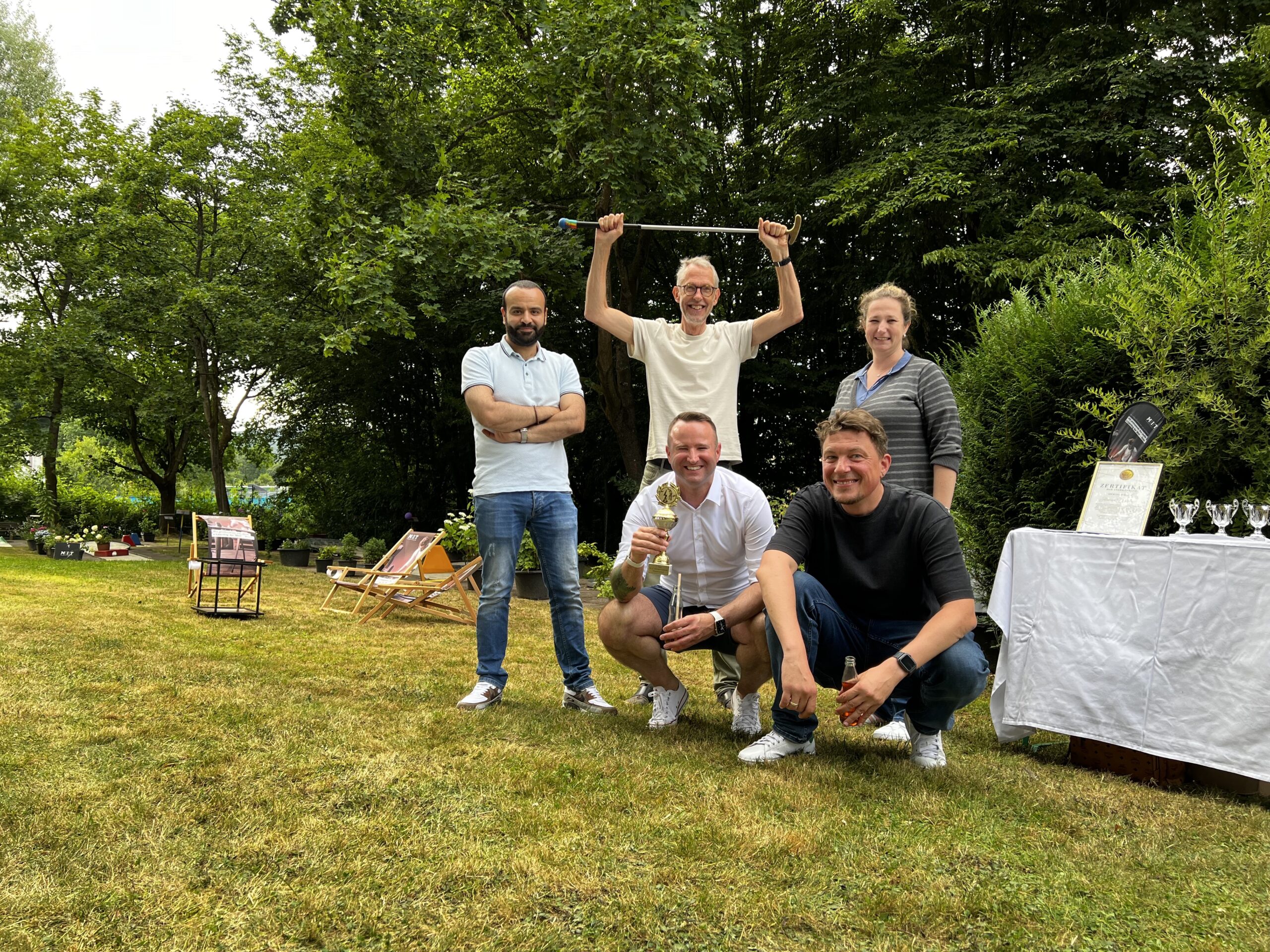 Sie sehen das :MIT-Vertriebs-Teams. Sie haben den Wanderpokal für das beste Minigolf-Team gewonnen.