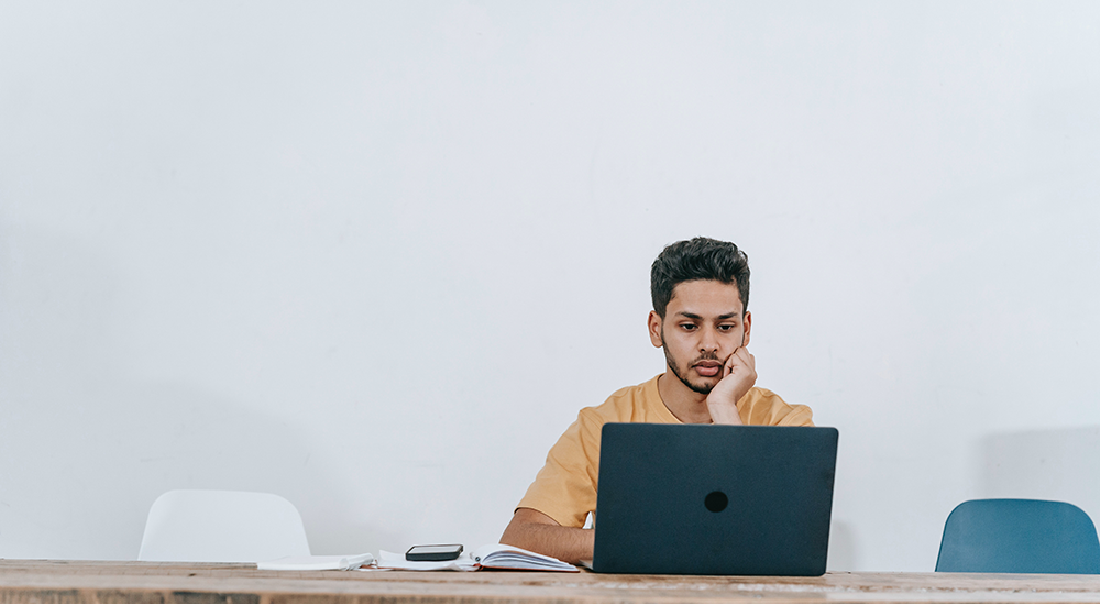 Sie sehen einen jungen Mann am Laptop. Dieses Bild ist das Titelbild der news zum Thema Standardcontent.