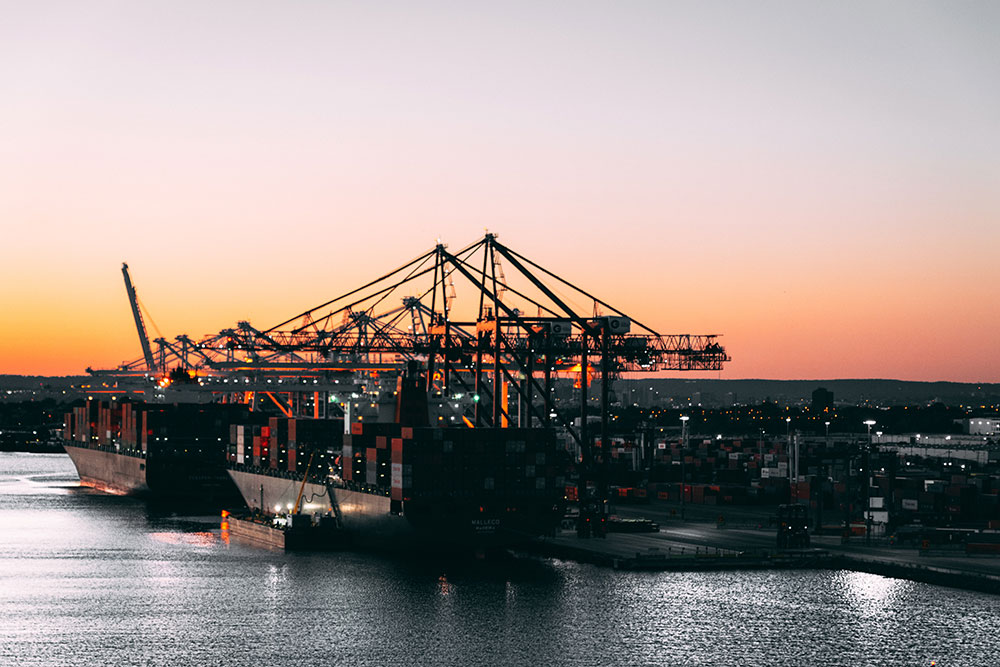 Sie sehen ein Dock an dem Frachtschiffe beladen werden. Es ist das Titelbild des Blogbeitrags "MARIDAL: Weiterbildung in der maritimen Logistikkette".